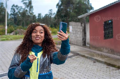 Pretty Latina Millennial Girl Talking On Her Cell Phone To Her Followers While Showing Her Rural