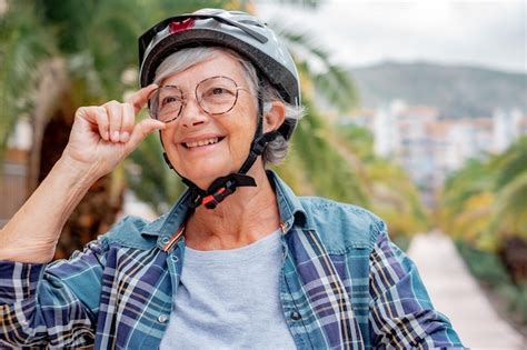 Retrato de uma bela ciclista sênior capacete correndo sua