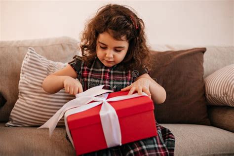 Brunette Kid Opening Birthday Present Indoor Shot Of Preteen Girl With Gift Stock Photo Image