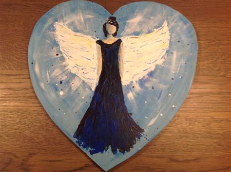 A Heart Shaped Painting With An Angel Painted On It