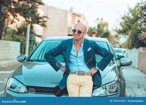 Successful Handsome Man Standing By His New Car Enjoying Summer Stock