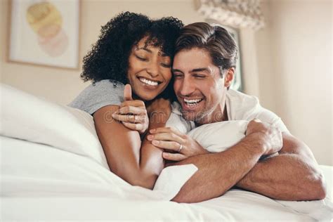 Interracial Couple Relax And Hug On Bed In Morning For Love Support