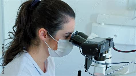 Dentist looking through dental microscope Stock Video | Adobe Stock