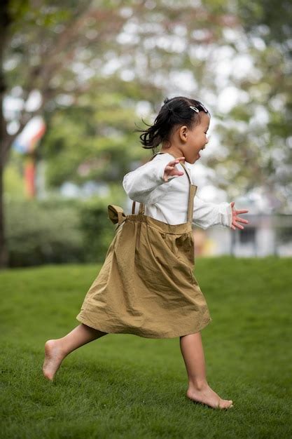 Chica Sonriente De Tiro Completo Corriendo Afuera Foto Gratis