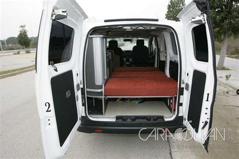 The Back End Of A White Van With Its Doors Open And Red Seats Folded Down