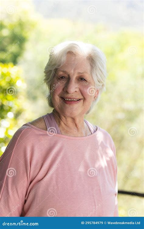 Portrait Of Happy Caucasian Senior Woman Standing And Smiling In Sunny