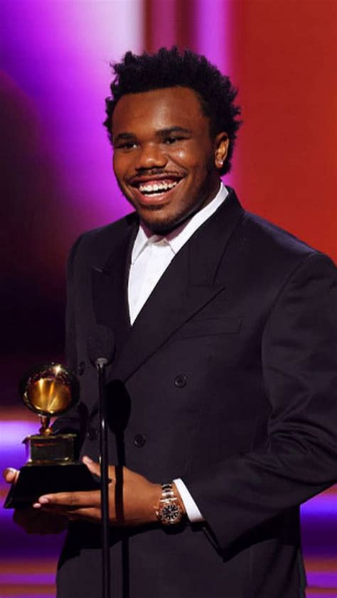 A Man In A Tuxedo Holding An Award