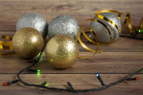 Gold and Silver Christmas Balls and Multi-colored Garland on a Wooden Christmas Background ...