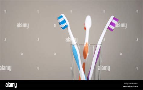 Three Colored Toothbrushes Stand On Shelf In Bathroom Care For Oral