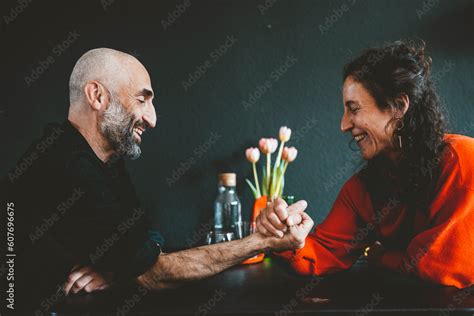 Happy woman arm wrestling with man in front of black wall Stock Photo ...