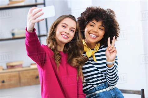 Portrait Of Cheerful Multiracial Young Women Taking Selfie Together