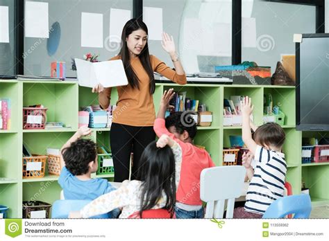 Young Asian Woman Teacher Teaching Kids In Kindergarten Classroom