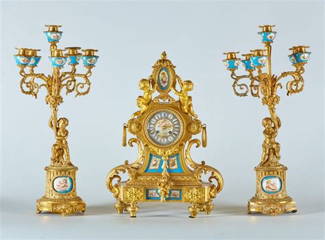 Trittico Composto Da Orologio E Due Candelabri In Bronzo Dorato Con