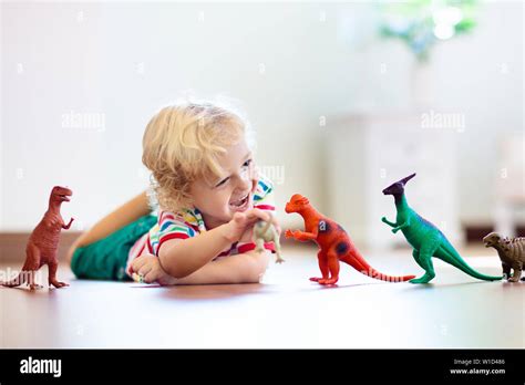 Child Playing With Colorful Toy Dinosaurs Educational Toys For Kids