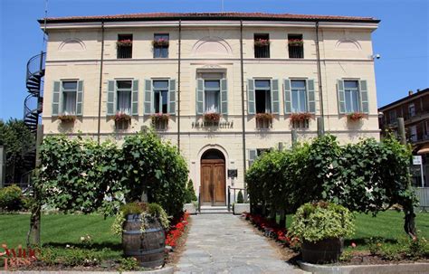 An Old Building With Many Windows And Plants In Front