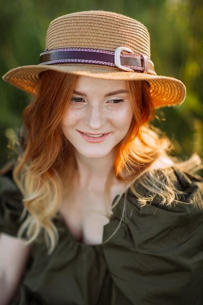 Uma garota ruiva entre dentes de leão no verão no campo 3630 Foto Premium