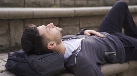 Young Man Lying On The Ground Outdoors Looking At The Sky Young Man