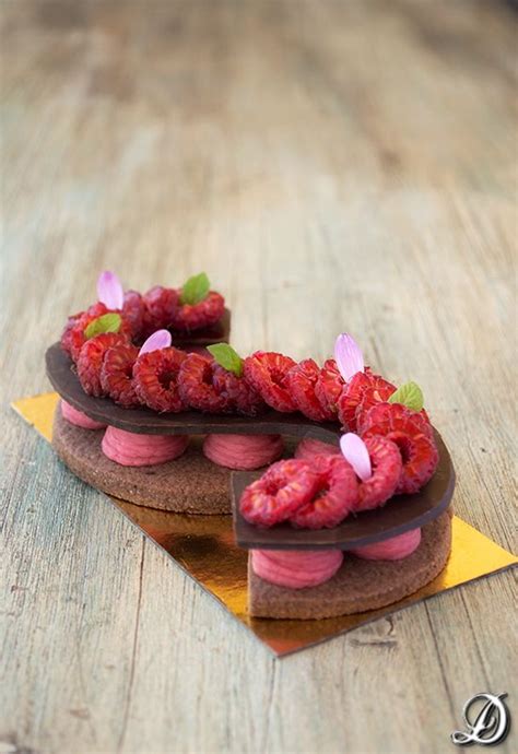 A Cake With Raspberries And Chocolate Frosting Sitting On Top Of A