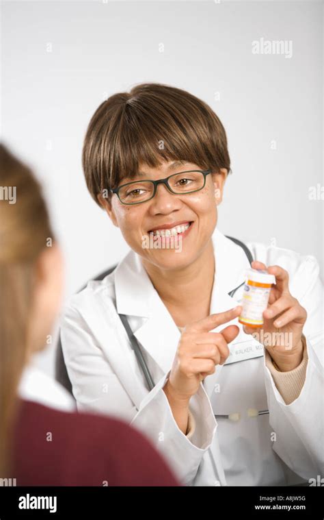 African American Middle Aged Female Doctor Sitting At Desk Explaining