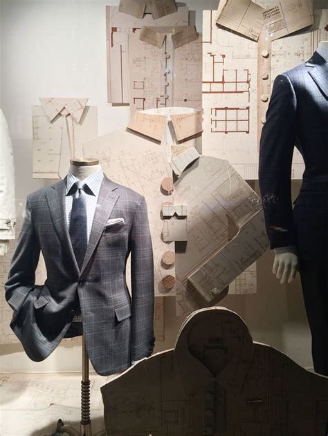 Two Mannequins Dressed In Suits And Ties Next To Architectural Drawings