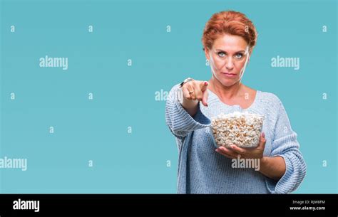 Atrractive Senior Caucasian Redhead Woman Eating Popcorn Over Isolated