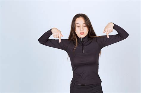 Fille En Vêtements Noirs Pointant Ci dessous Photo Gratuite