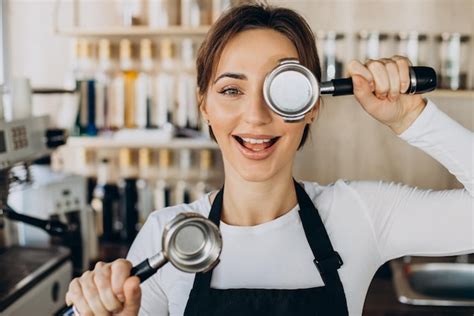 Mulher barista em uma cafeteria preparando café Foto Grátis