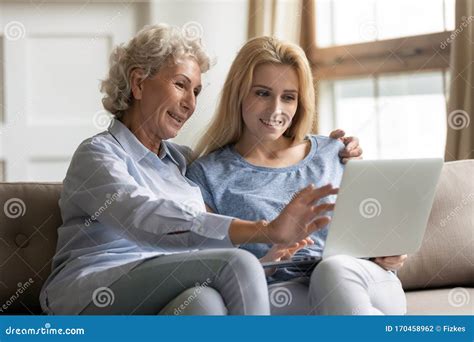 Happy Young Woman Teaching Elderly Mother Use Applications On Laptop