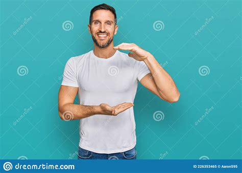 Handsome Man With Beard Wearing Casual White T Shirt Gesturing With Hands Showing Big And Large