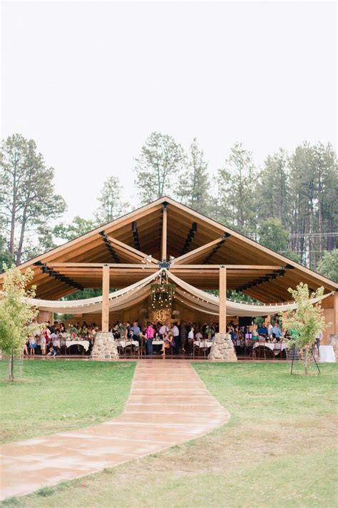 a group of people sitting at tables under a wooden structure in the ...