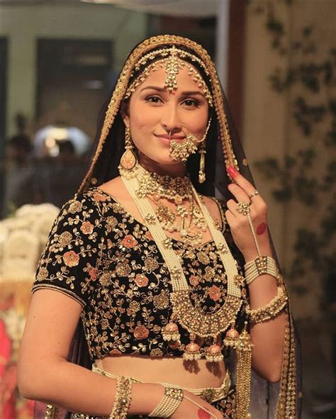 A Woman In A Black And Gold Bridal Outfit