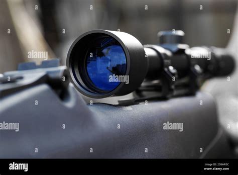 Closeup Of Telescopic Sight With Reflection In Lens Mounted On Rifle