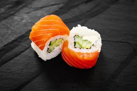 Rolos de maki de sushi de salmão recheio de abacate e pepino em