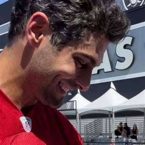 A Close Up Of A Person Wearing A Red Shirt And Smiling At Something In