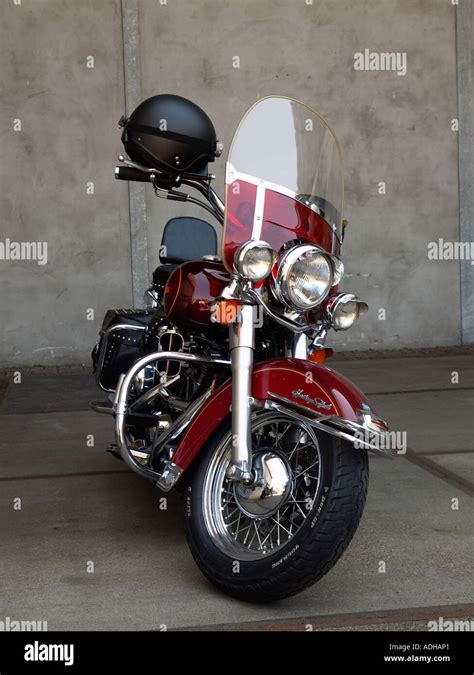 Rojo cereza Harley Davidson Heritage Softail motocicleta estacionada Vista frontal con el casco ...