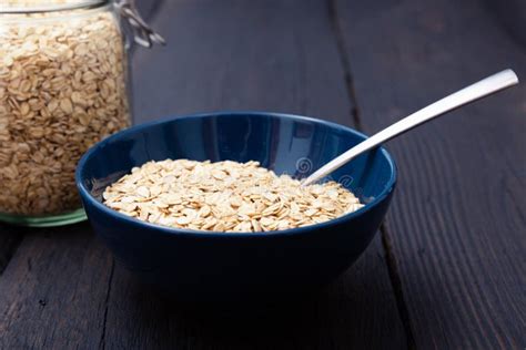 Rolled Oats Healthy Breakfast Cereal Oat Flakes In Bowl On Dark Wooden