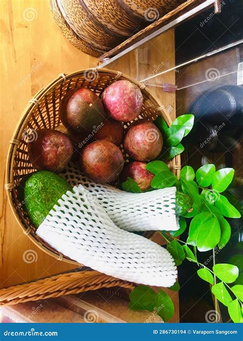 Passion Fruit And Avocado Fruit In A Bamboo Wicker Tray Placed On A Beautiful Wooden Table Stock