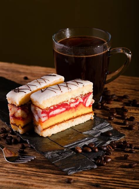 Two Slices Of Sweet Dessert On Black Stone With Coffee Stock Photo