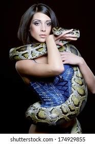 Sexy Brunette Holding Python Over Black Stock Photo