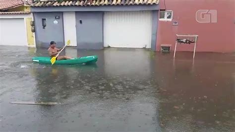 Homem navega de caiaque por ruas alagadas após temporal em Cabo Frio