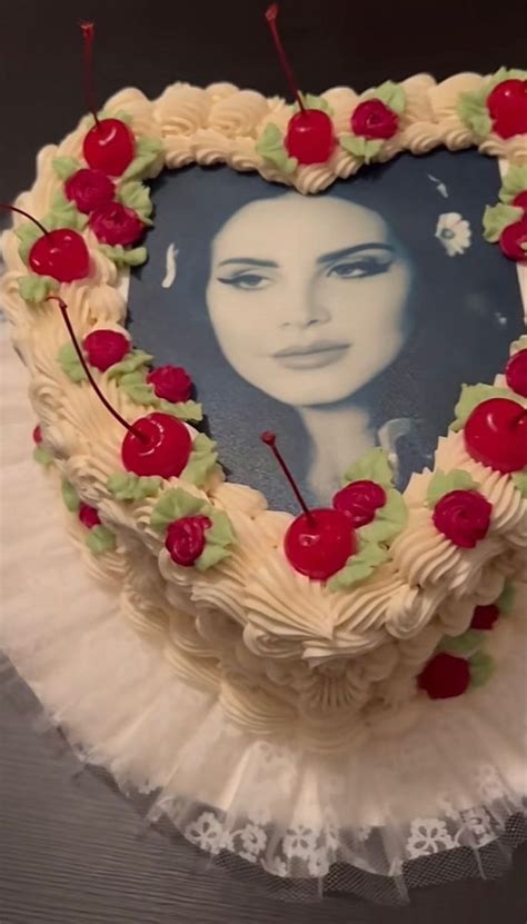 A Heart Shaped Cake Decorated With Cherries And An Image Of A Womans Face