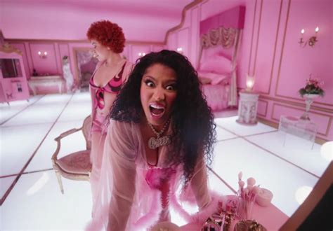 a woman in pink dress standing next to a table