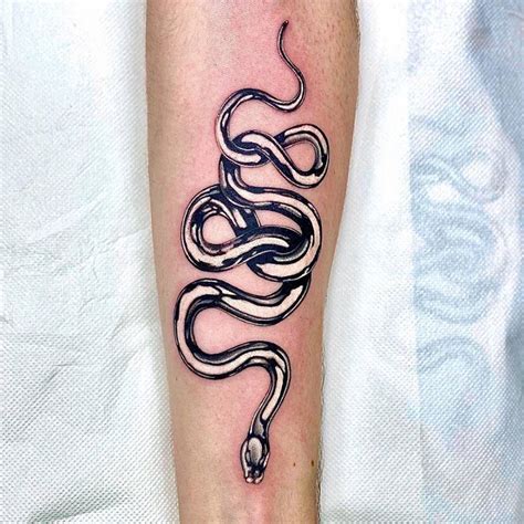 Metallic snake tattoo on the inner forearm.