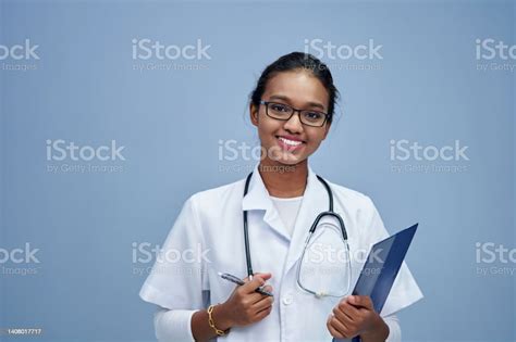 Female Doctor Wearing Lab Coat And Stethoscope Holding Clipboard Stock