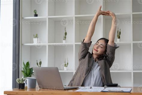 Asian businesswoman stretches her arms to relax her tired muscles from