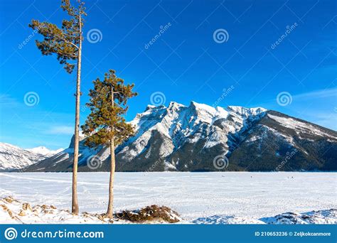 Windy Day On A Frozen Mountain Lake And Snowy Mountain Peak On Horizon