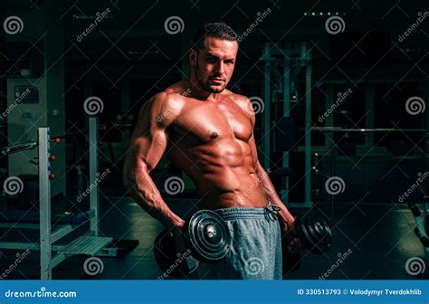 Bodybuilder In Gym Training And Workouts Dumbbells Exercises