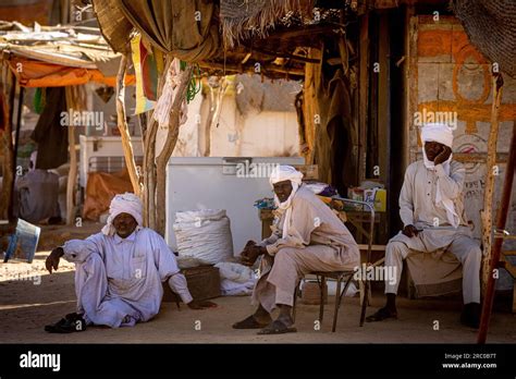 In the rural market of Chad, three men dressed in traditional clothes ...