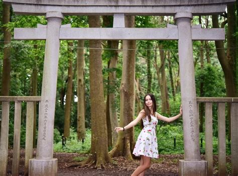 Premium Photo Portrait Of Woman Standing Against Torii Gate