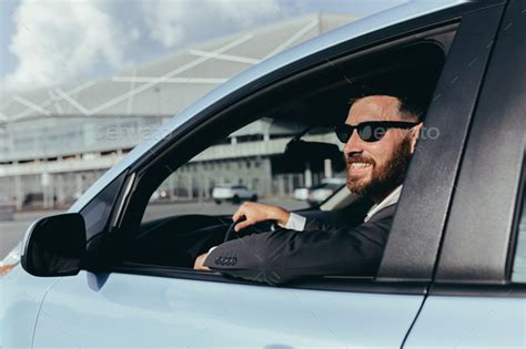 Businessman In Black Glasses Sitting Behind The Wheel Of A Car Stock